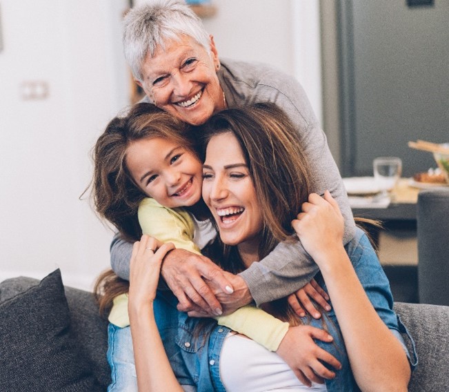 three generations of women laughing and hugging