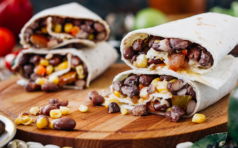 Black bean burritos on a wooden serving platter