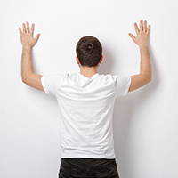 Man stretching against wall